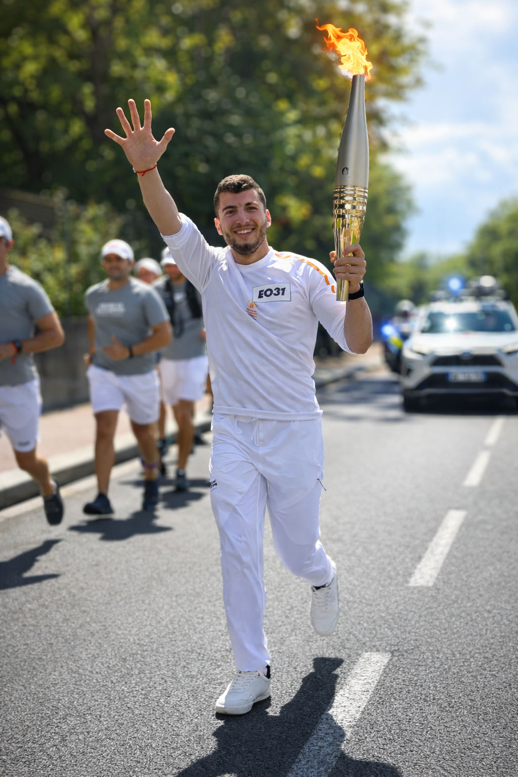 Hazem Nader porteur de la flamme olympique Paris 2024, torche levée dans la rue